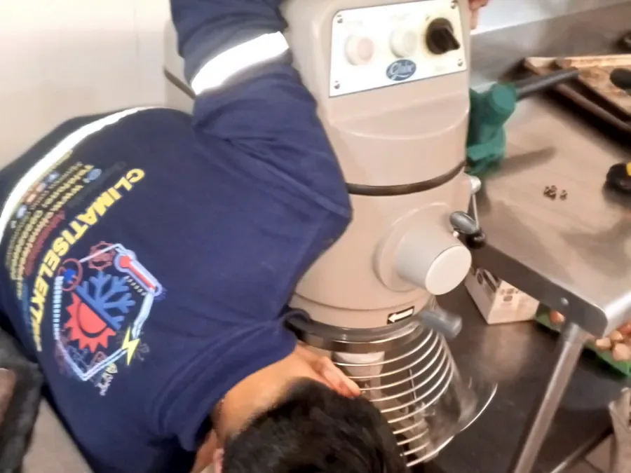 Técnico de Climatiselektric reparando una batidora industrial en una cocina